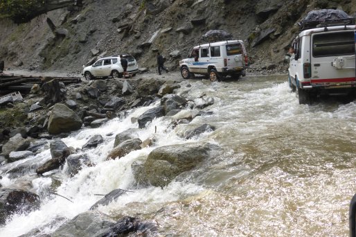 Slow moving traffic, waterfall meets road in Arunachal Pradesh.
